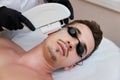 Young man receiving epilation in beauty center. laser hair removal procedure Royalty Free Stock Photo