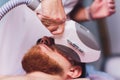 Young Man Receiving Laser Hair Removal Treatment At Beauty Center. Royalty Free Stock Photo