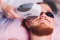 Young Man Receiving Laser Hair Removal Treatment At Beauty Center. Royalty Free Stock Photo