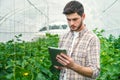 Young man recording measurements in a greenhouse Royalty Free Stock Photo