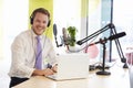 Young man recording a podcast smiling to camera, close up