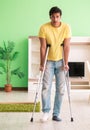 Young man recovering after accident at home with crutches Royalty Free Stock Photo