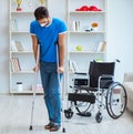 Young man recovering after surgery at home with crutches and a w Royalty Free Stock Photo