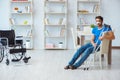 Young man recovering after surgery at home with crutches and a w Royalty Free Stock Photo