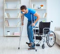 Young man recovering after surgery at home with crutches and a w Royalty Free Stock Photo