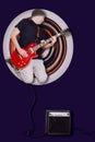 Young man with the red guitar in the jump on the round background of stretched pixels. Male Rock music concept Royalty Free Stock Photo