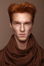 Young man with red hair and creative make up and hair.