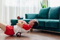 A young man in red shorts is doing exercises on a foam roller, works out of the muscles with a massage roller. Athletic