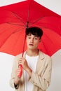 A young man red umbrella a man in a light jacket  background unaltered Royalty Free Stock Photo