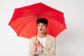 A young man red umbrella a man in a light jacket  background unaltered Royalty Free Stock Photo