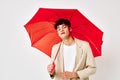 A young man red umbrella a man in a light jacket  background unaltered Royalty Free Stock Photo