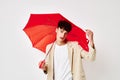 A young man red umbrella a man in a light jacket isolated background unaltered Royalty Free Stock Photo