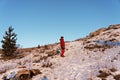 Young man in red winter clothes hiking and climbing the mountain against the blue sky in winter Royalty Free Stock Photo