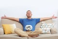 Young man refreshing in front of small fan at home. Royalty Free Stock Photo