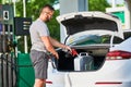 Young man refueling canister with fuel.