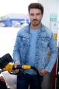 young man refuelling car at petrol station