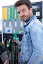 young man refuelling car at petrol station