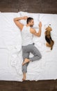 Young man relaxation on the bed top view sleeping with a dog Royalty Free Stock Photo