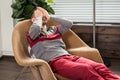 Man relaxes, lies in chair, covering his face with his hands Royalty Free Stock Photo