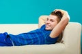 Young man relaxing on couch on blue Royalty Free Stock Photo