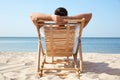 Young man relaxing in deck chair on  beach Royalty Free Stock Photo