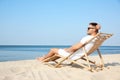 Young man relaxing in deck chair Royalty Free Stock Photo