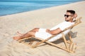 Young man relaxing in deck  on sandy beach Royalty Free Stock Photo