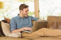 Young man relaxing on his couch with laptop Royalty Free Stock Photo