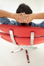 Young man relaxing in red chair Royalty Free Stock Photo