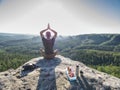 Young man relaxing on rocky cliff. Man sitting on rock point