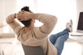 Young man relaxing at table in office Royalty Free Stock Photo