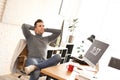 Young man relaxing at table in office Royalty Free Stock Photo