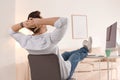 Young man relaxing at table in office Royalty Free Stock Photo