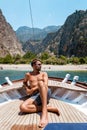 Young man relaxing on a wooden boat during a boat trip to Butterfly beach at Fethiye Turkey, Tanning young boy in swim Royalty Free Stock Photo