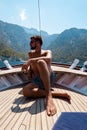 Young man relaxing on a wooden boat during a boat trip to Butterfly beach at Fethiye Turkey, Tanning young boy in swim