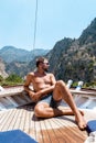 Young man relaxing on a wooden boat during a boat trip to Butterfly beach at Fethiye Turkey, Tanning young boy in swim Royalty Free Stock Photo