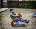 Young man reliving his childhood playing in playground