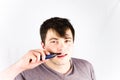 Young man remove hair from his nose with trimmer. Handsome young man removes nose hair with electric shaver. Beauty and people con
