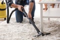 Young man removing dirt from carpet with vacuum cleaner Royalty Free Stock Photo