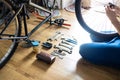 Young man repairing a bicycle at home. repairman installing assembling or adjusting bicycle gear on wheel in workshop. Royalty Free Stock Photo