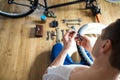 Young man repairing a bicycle at home. repairman installing assembling or adjusting bicycle gear on wheel in workshop. Royalty Free Stock Photo