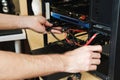 Young man repairs a computer system unit, changes parts, video card and hard drive, sets new components. Computer Repair Royalty Free Stock Photo