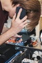 Young man repairs a computer system unit, changes parts, video card and hard drive, sets new components. Computer Repair Royalty Free Stock Photo