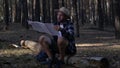 Young man resting and checking the map while hiking in the mountains or forest