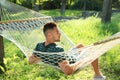 Young man resting in comfortable hammock at garden Royalty Free Stock Photo