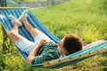 Young man resting in comfortable hammock at garden Royalty Free Stock Photo