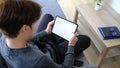 Young man resting on comfortable sofa and using digital tablet. Royalty Free Stock Photo