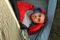 Young man resting in sleeping bag inside camping tent