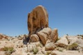 Young man rests under enormous rock at Joshua Tree National Park, CA, USA. Travel concept. Horizontal Royalty Free Stock Photo