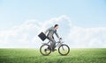 Young man riding bicycle on green grass